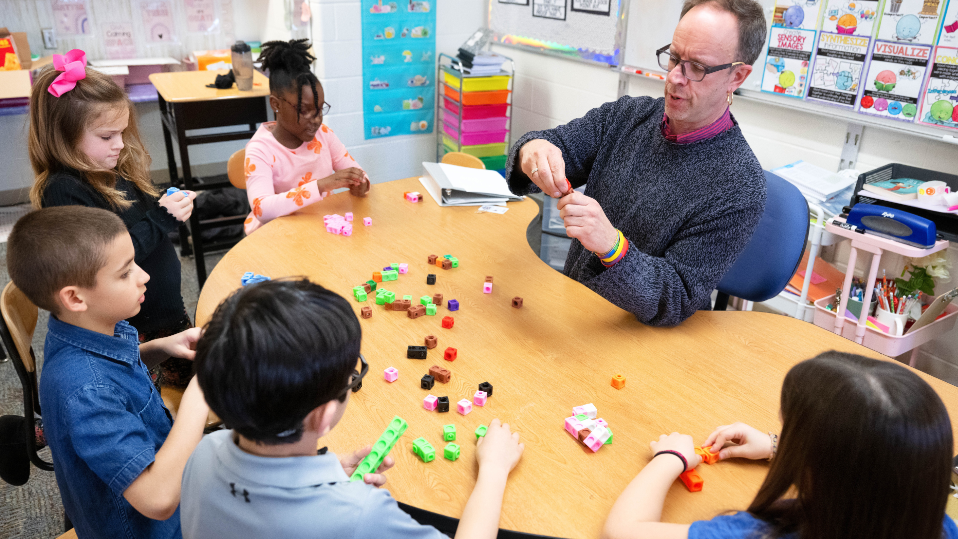 Teacher working at table with four students