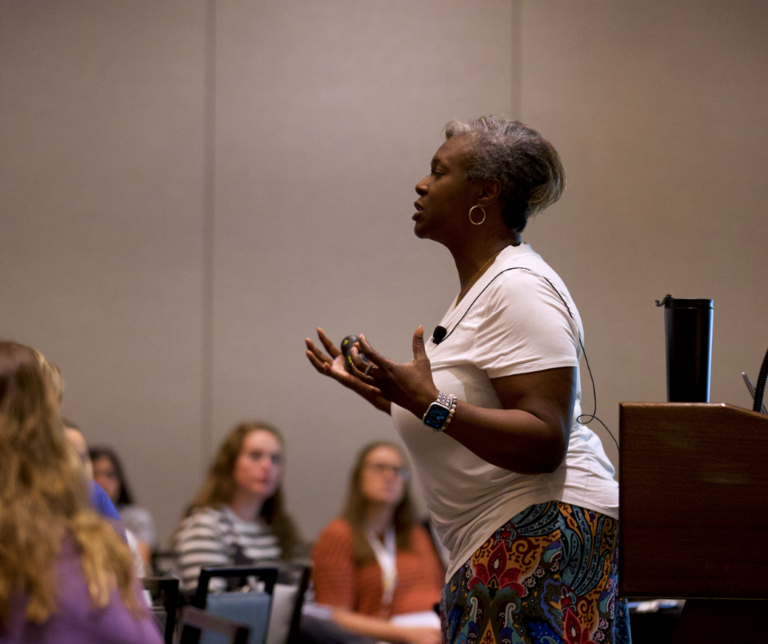 woman presenting at front of room