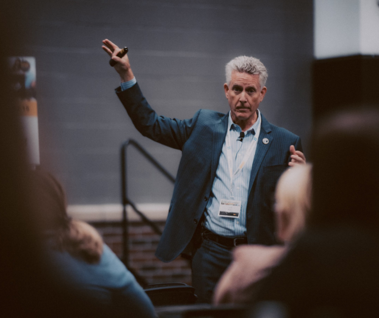 man presenting at front of room