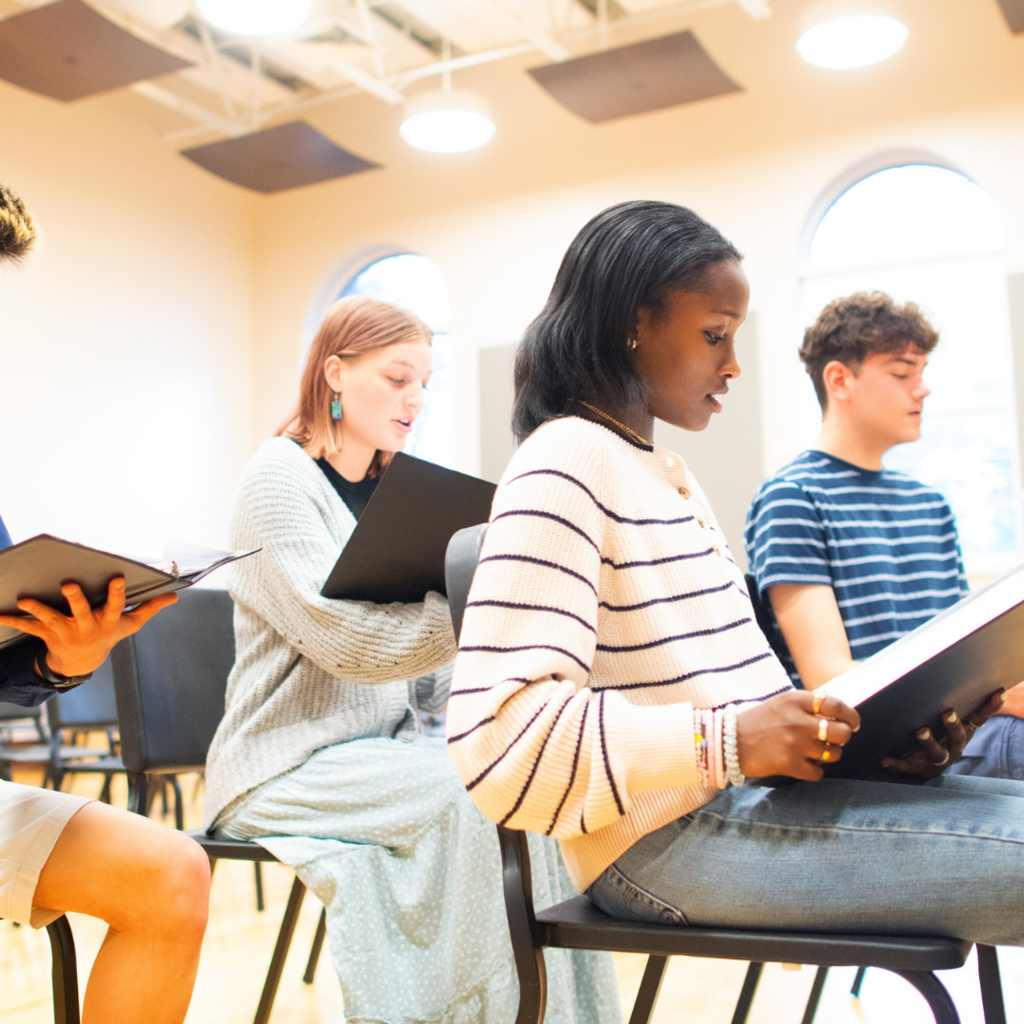 four students reading music