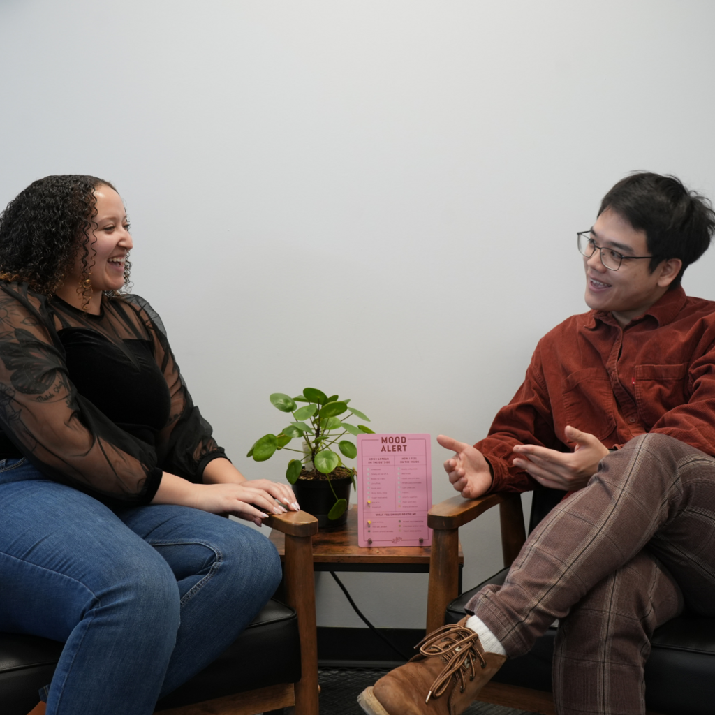 Two staff members talking to each other smiling