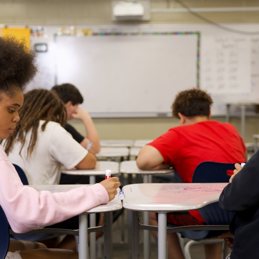 Four middle school students sitting at desks