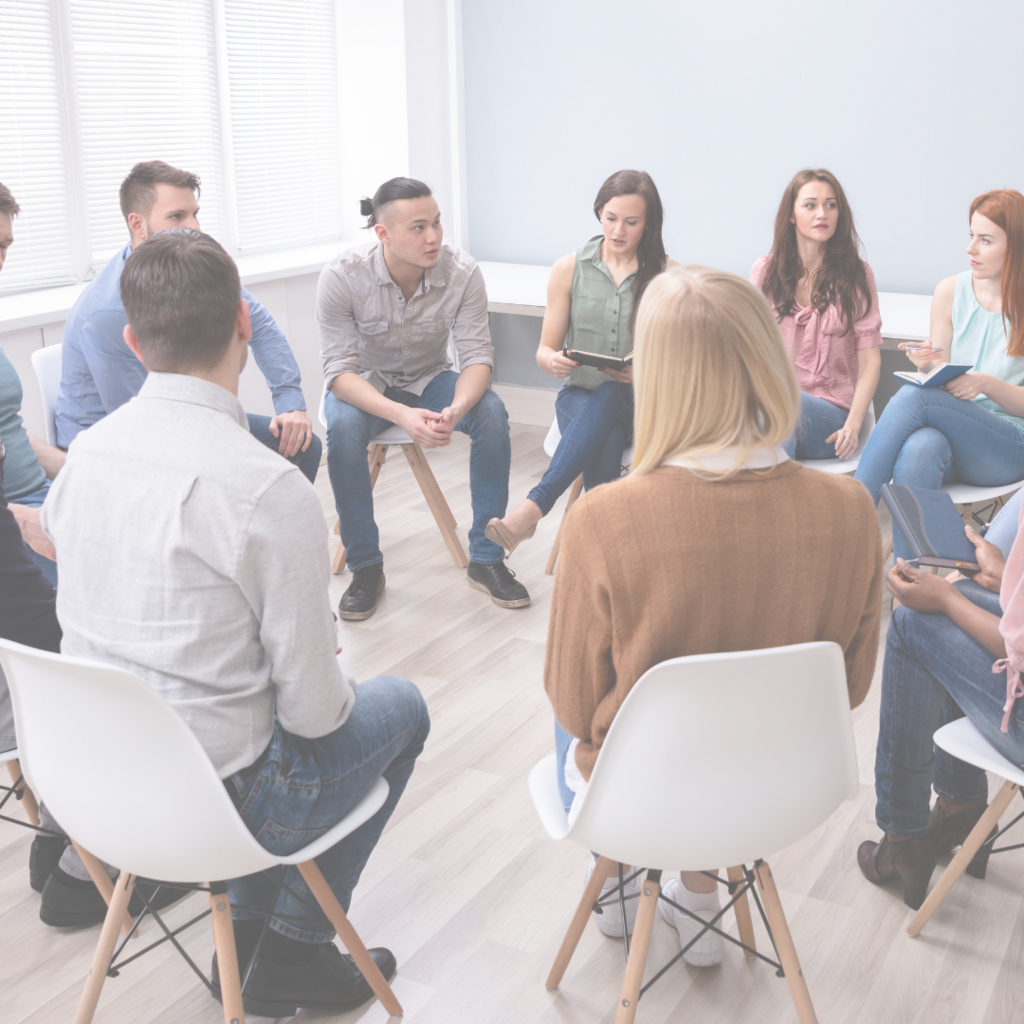 Group of eight adults sitting in a circle talking