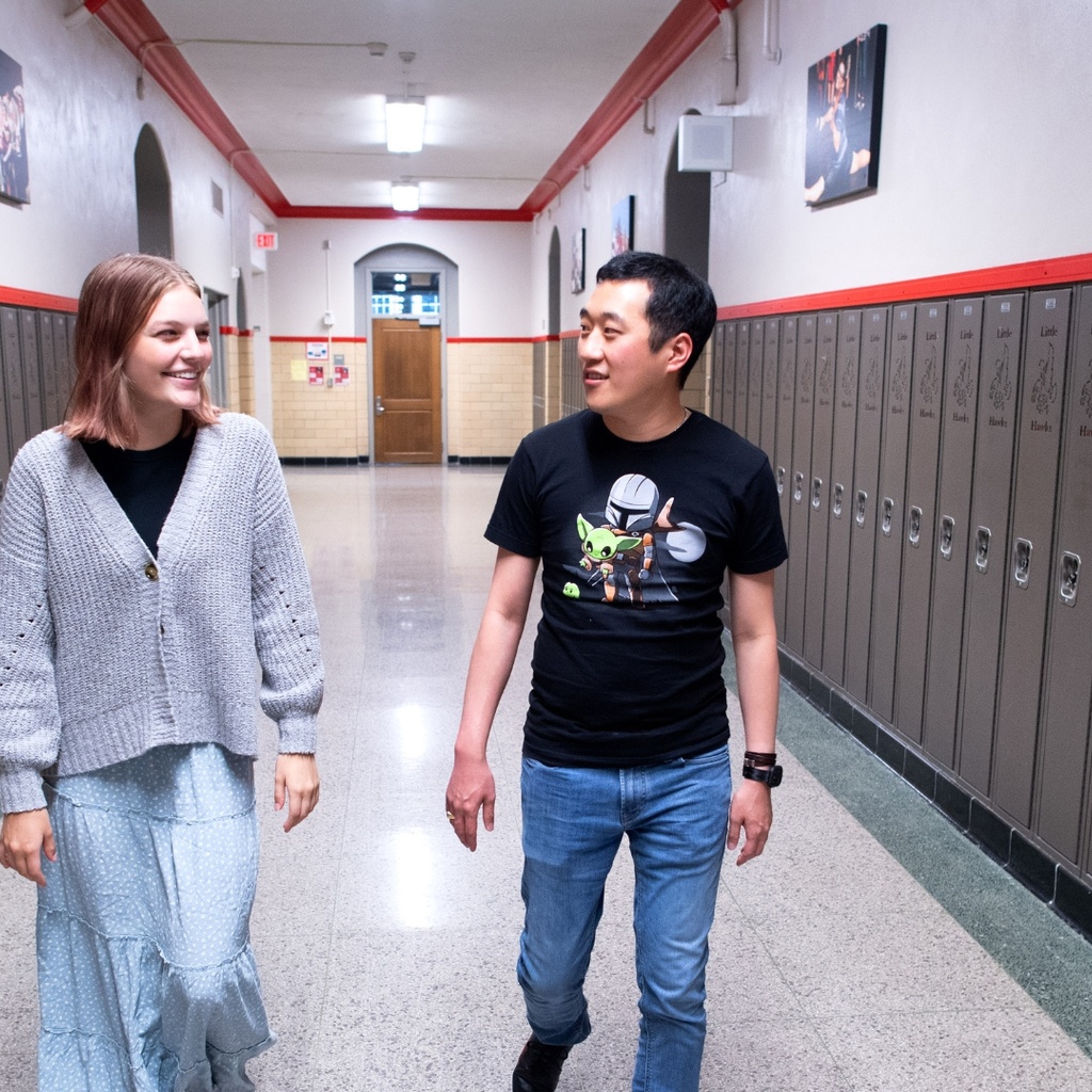 Teacher and student walking down the hallway in a school