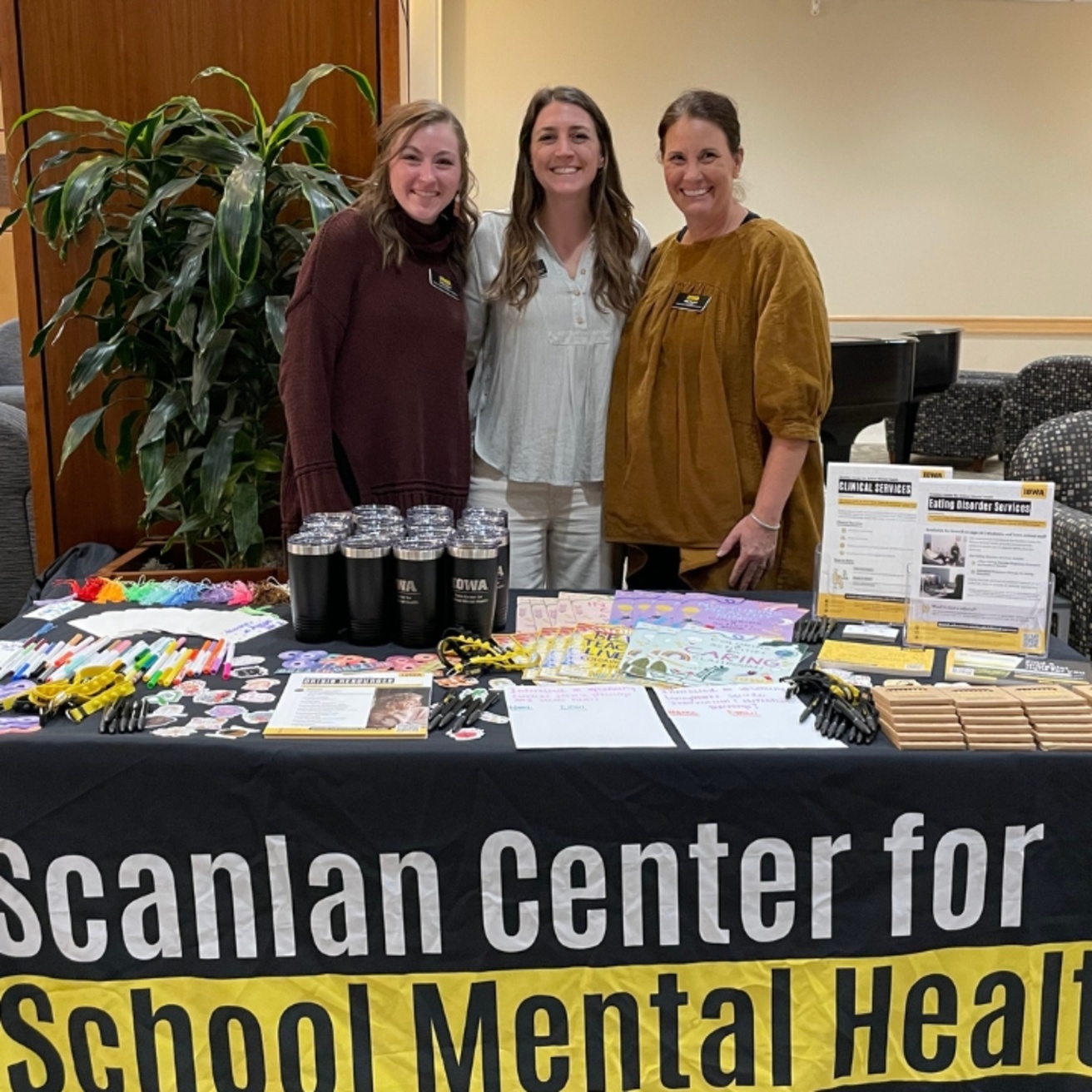 Three Scanlan Center staff members staffing an outreach table at a special event