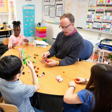 Teacher with students at table