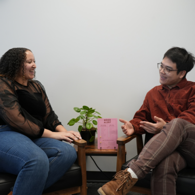 Two staff members talking to each other smiling