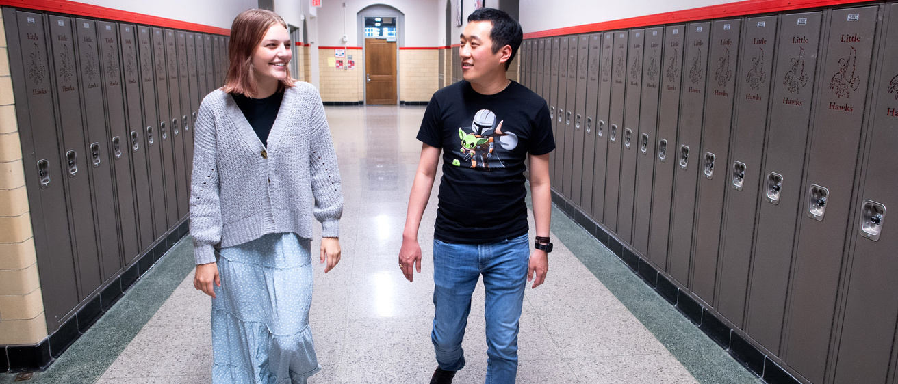 Teacher and student walking in hallway