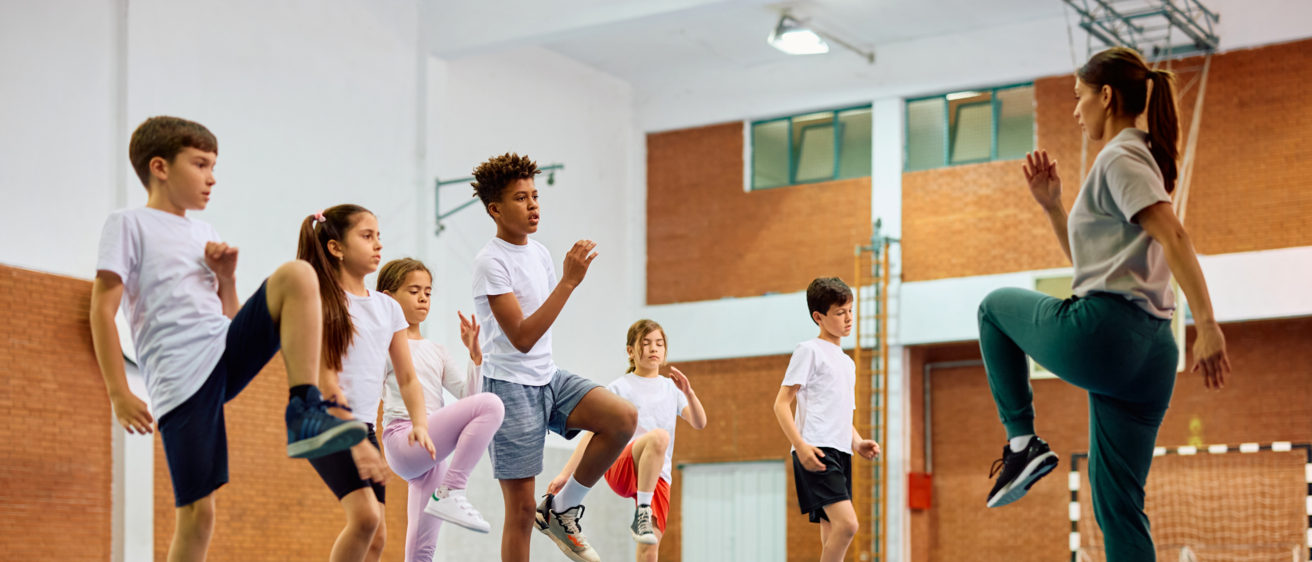 Teacher and students doing exercise in gym
