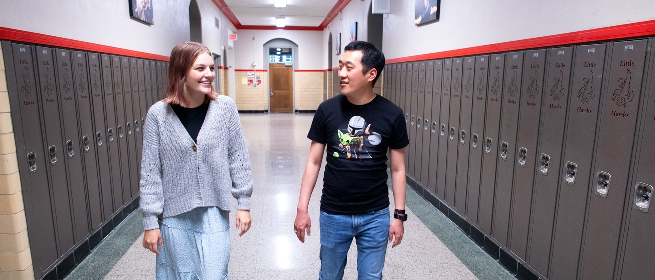 Teacher and student walking down the hallway in a school