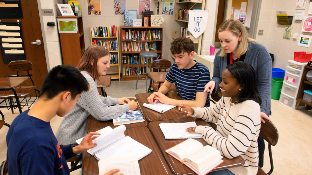 teacher helping four students