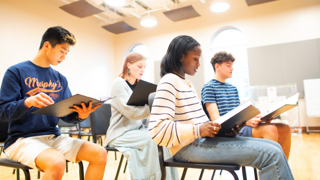 four students reading music