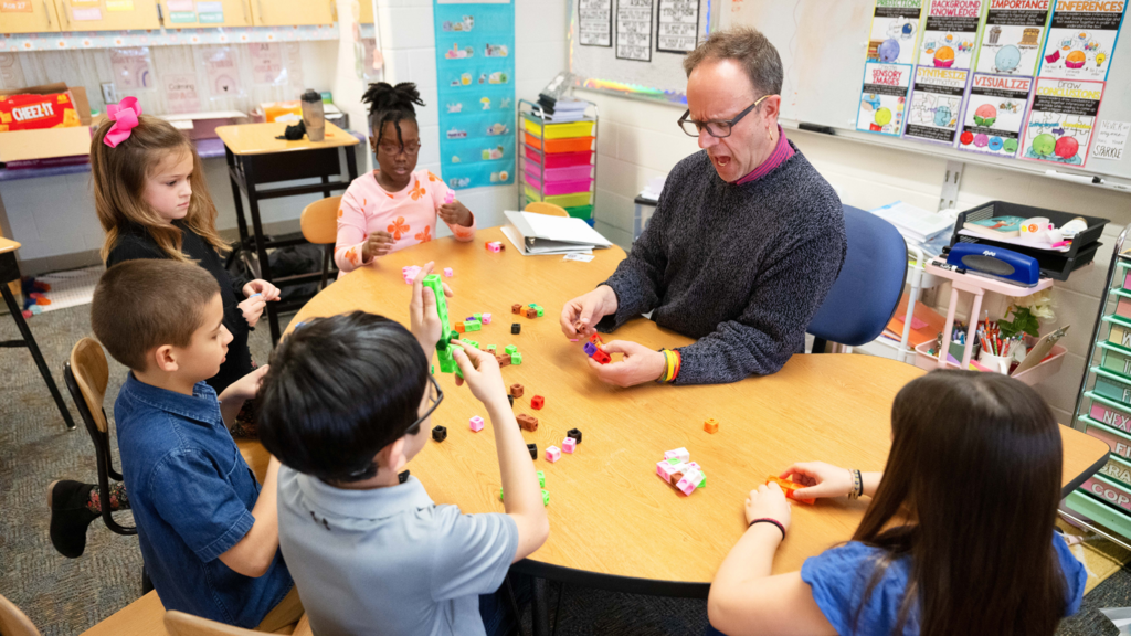 Teacher with students at a table