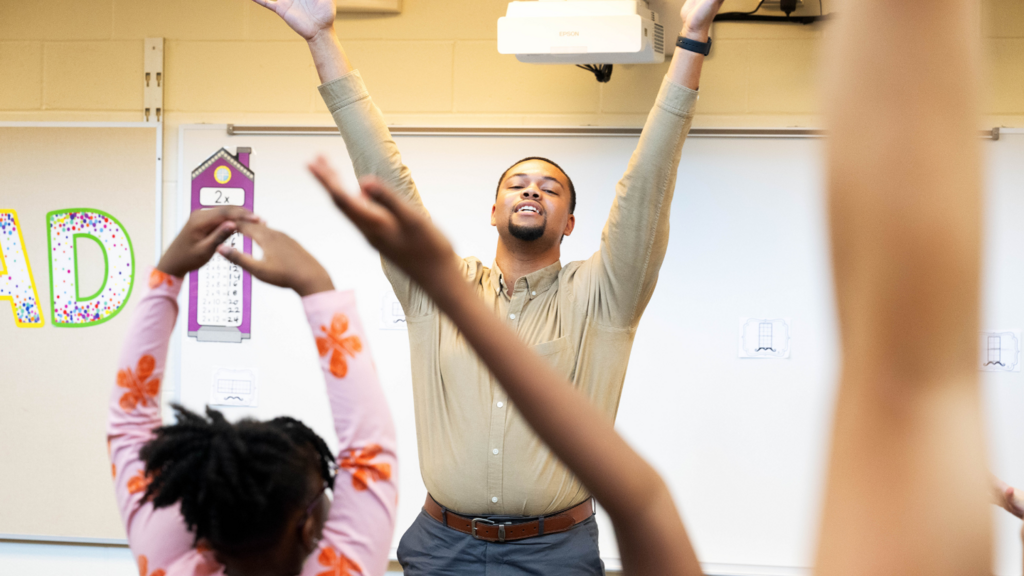 Teacher stretching in front of classroom