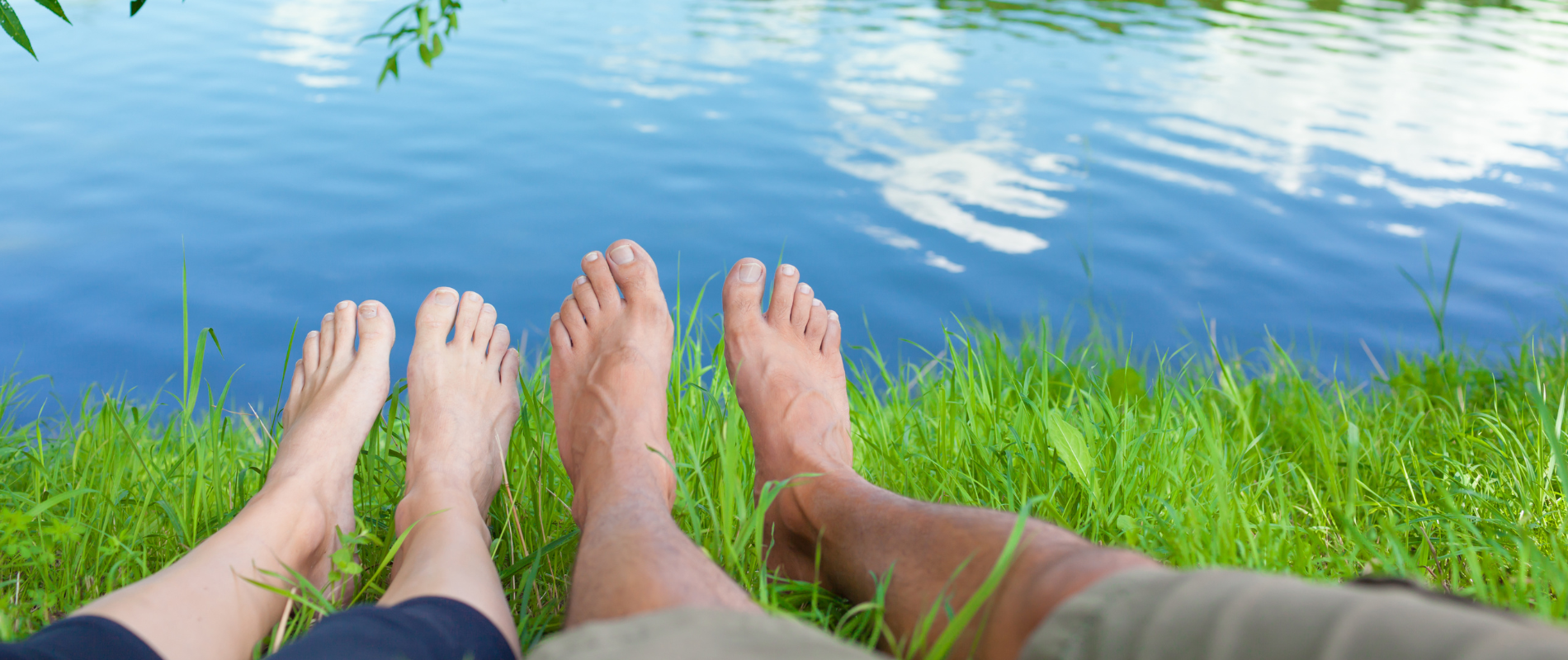 Two pairs of feet by water