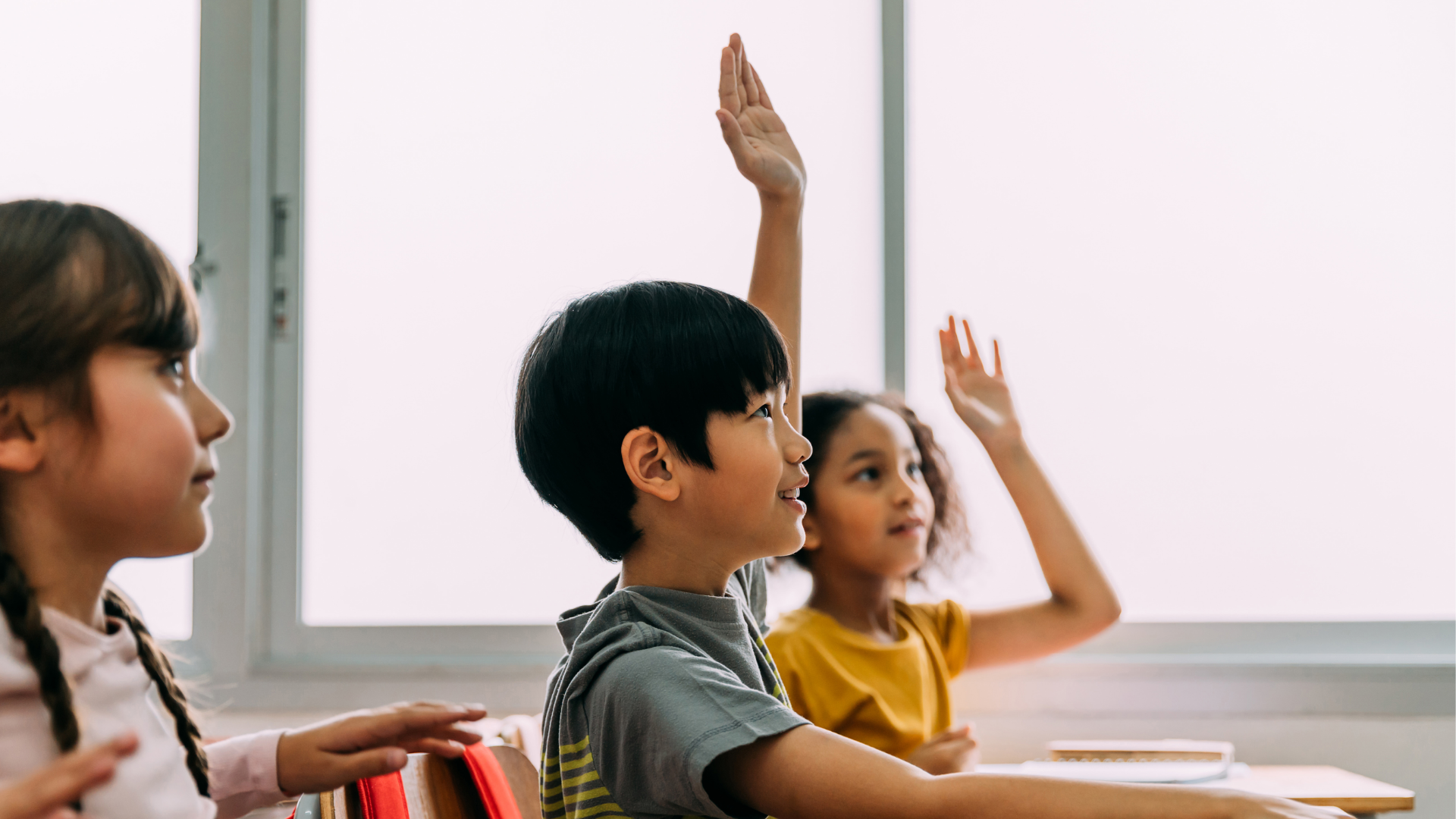 Boy raising hand in classroom