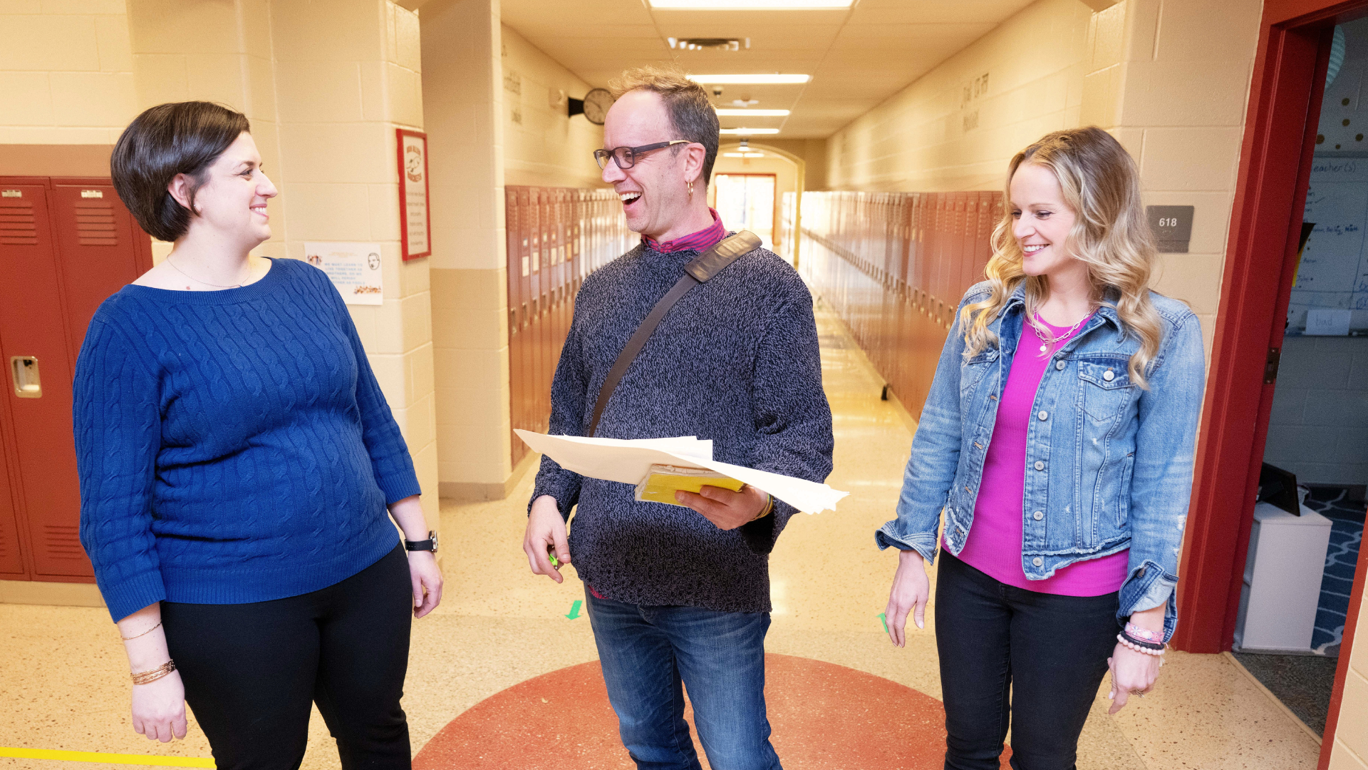 3 people walking in hallway